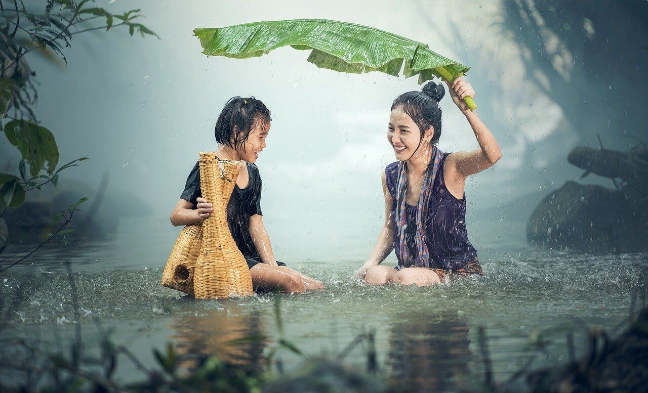 Woman and Little Girl trusting in the power of authenticity by laughing in the rain
