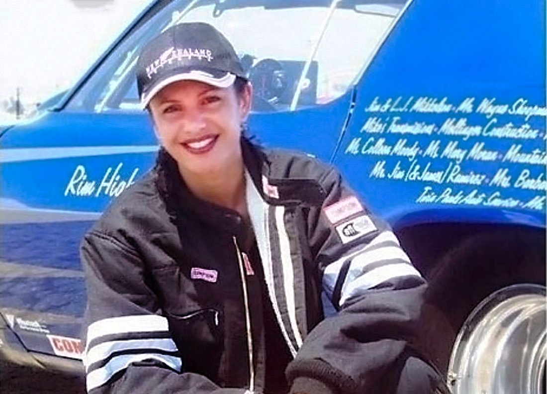 Blumvox Studios team member Reirani in front of a blue racecar
